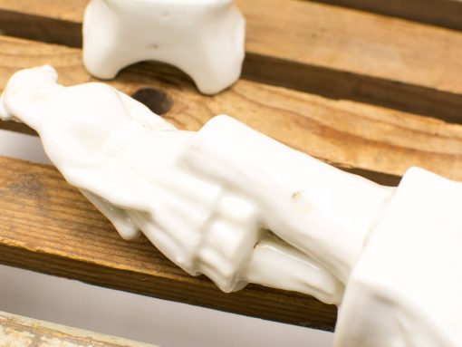 Elegant vintage porcelain figurines on rustic wooden surface, showcasing craftsmanship and timeless beauty.
