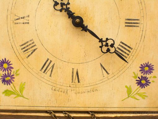 Antique clock with floral details and Roman numerals, crafted by L. Graeb, Groningen.