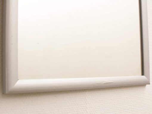 Minimalist rectangular mirror with light frame, offering subtle elegance and character.