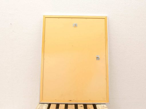 Functional yellow door on wooden pallet, ideal for storage spaces or workshops.