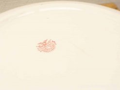 Elegant vintage ceramic plate featuring a distinctive red makers mark, perfect for collectors and decor.