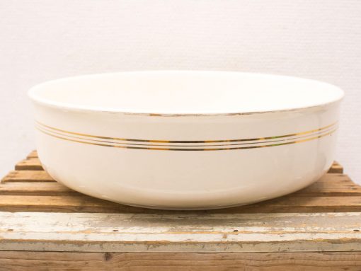 Elegant white bowl with gold and charcoal stripes on a rustic wooden base.