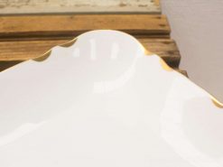 Elegant white porcelain plate with gold trim, perfect for dining and decorative displays.