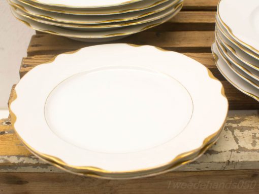 Elegant vintage white plates with a delicate gold rim, perfect for special occasions.