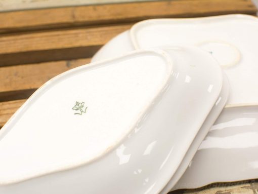 Elegant white ceramic dishes with rose design, perfect for special occasions and refined dining experiences.