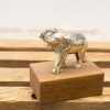 Intricate silver elephant sculpture on wooden base, symbolizing luck and strength for elegant decor.