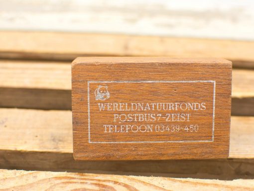 Polished wooden block with Wereld Natuur Fonds logo and contact information for conservation efforts.