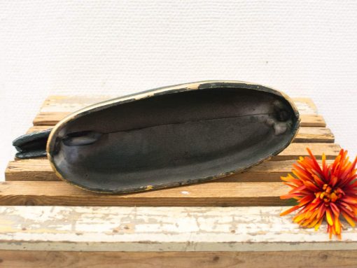 Vintage shoe last with antique charm and vibrant flower accent on rustic wooden background.
