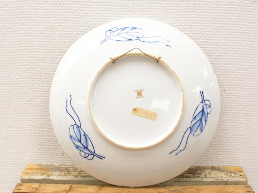 Elegant blue porcelain wall plate with minimalist floral design, perfect for decor.