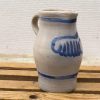 Handmade clay jug with blue design, combining rustic charm and functional elegance.