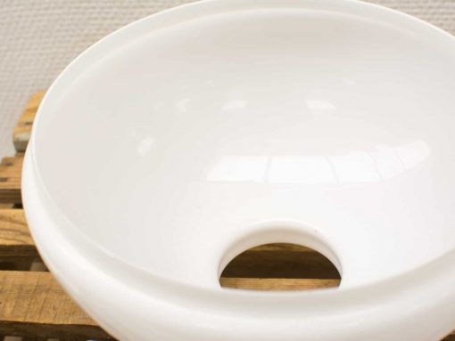 Elegant white bowl with hole, perfect for decor or practical uses like planting.