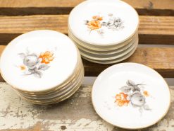 Elegant vintage porcelain plates with delicate floral designs and gold accents for charming table settings.