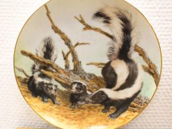 Vintage plate featuring playful skunks in a serene natural setting with soft pastel colors.