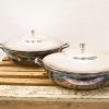 Elegant stainless steel cooking pots on a rustic wooden surface, blending style and functionality.