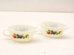 Charming vintage gravy boats with botanical designs in milky glass, perfect for festive meals.