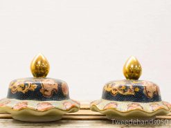 Elegant decorative bowls with golden lids and intricate navy designs perfect for any interior.
