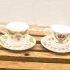 Elegant vintage teacup and saucer set featuring intricate floral designs and gold accents.