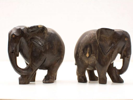 Handcrafted dark wooden elephant figurines, showcasing playful and serene designs, perfect for decor.