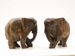 Intricately carved wooden elephant figurines showcasing unique styles and craftsmanship, perfect for home decor.