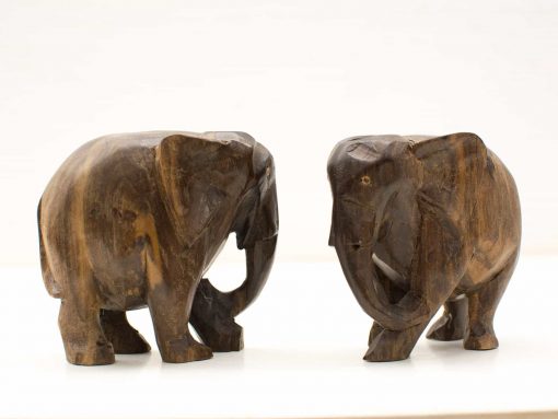 Intricately carved wooden elephant figurines showcasing unique styles and craftsmanship, perfect for home decor.
