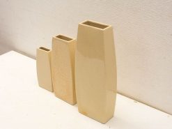 Elegant set of three modern beige vases for contemporary home decor and floral arrangements.