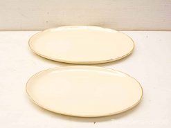 Elegant vintage oval platters with gold trim for timeless dining and decor.