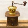 Antique wooden coffee grinder with brass bowl, perfect for traditional coffee lovers and decor.