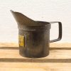 Nostalgic vintage metal measuring jug with yellow label, perfect for precise pouring in rustic kitchens.