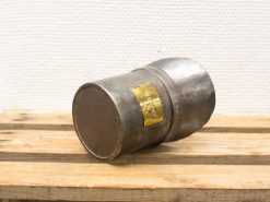 Vintage metal cylinder with label, perfect for industrial decor or functional use.