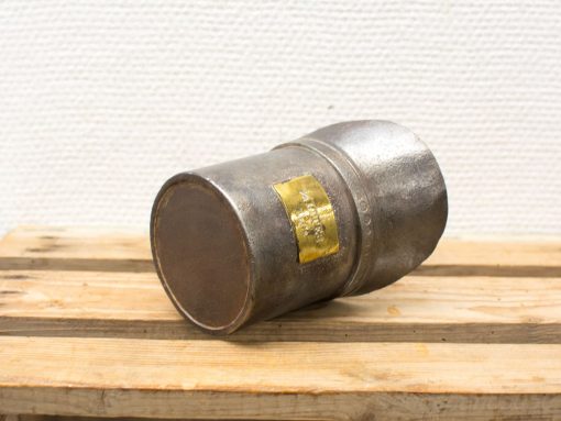 Vintage metal cylinder with label, perfect for industrial decor or functional use.