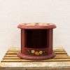 Charming red wooden display stand with hand-painted floral motifs, perfect for showcasing decor.