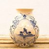 Elegant Delftware vase featuring a serene windmill landscape and floral designs in blue and white.