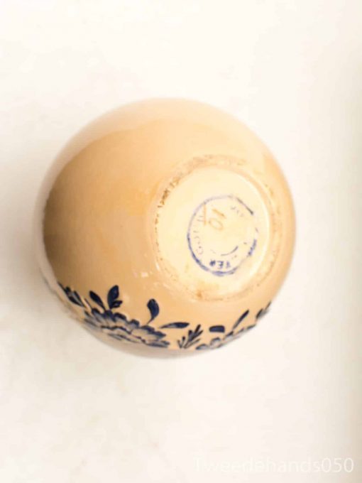 Beige ceramic bowl with blue floral design, perfect for decor or tableware.