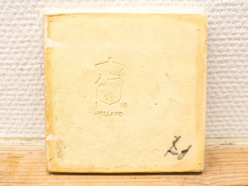 Vintage yellow Dutch tile with embossed shield and crown, ideal for collectors.