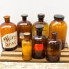 Vintage brown glass bottles on a wooden crate, featuring a notable WALVIS TRAAN label.
