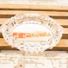 Vintage glass ashtray featuring a nostalgic retro diner image on a rustic wooden surface.