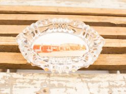 Vintage glass ashtray featuring a nostalgic retro diner image on a rustic wooden surface.