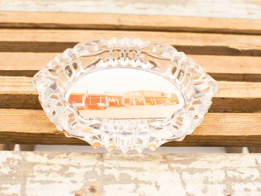 Vintage glass ashtray featuring a nostalgic retro diner image on a rustic wooden surface.