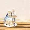 Charming porcelain figurine of playful children in traditional attire, perfect for collectors.