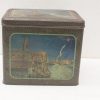 Antique tin box featuring a charming coastal scene, perfect for storage or decor.