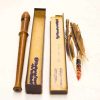Vintage wood wind instrument with accessories, including boxes and decorative feathers for musical nostalgia.