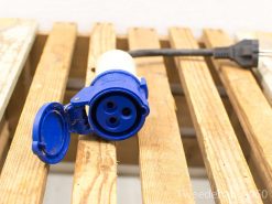 Blue industrial electrical connector with heavy-duty cable on wooden pallet backdrop.