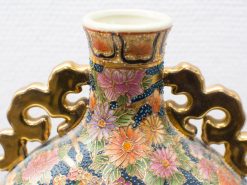 Elegant ceramic vase with intricate floral motifs in vibrant pastels and gold accents.