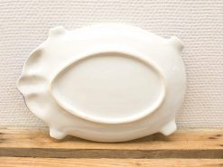Elegant oval porcelain serving platter with a vintage design and convenient handles.