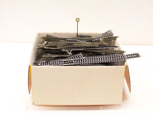 Vintage model train track set in a repurposed box with signal marker included.
