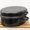 Vintage oval roasting pan with glossy black finish, ideal for elegant cooking and serving.