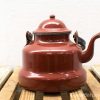 Charming vintage red enamel kettle, ideal for hot beverages and stylish kitchen decor.