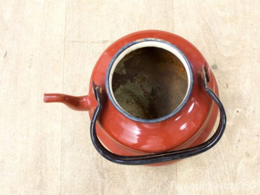 Vintage red kettle with glossy finish, rich history, and charming design. Perfect for any kitchen.