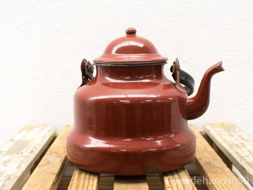 Charming vintage red enamel kettle, ideal for hot beverages and stylish kitchen decor.