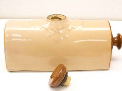 Vintage ceramic container with lid, ideal for storing liquids in a rustic home setting.